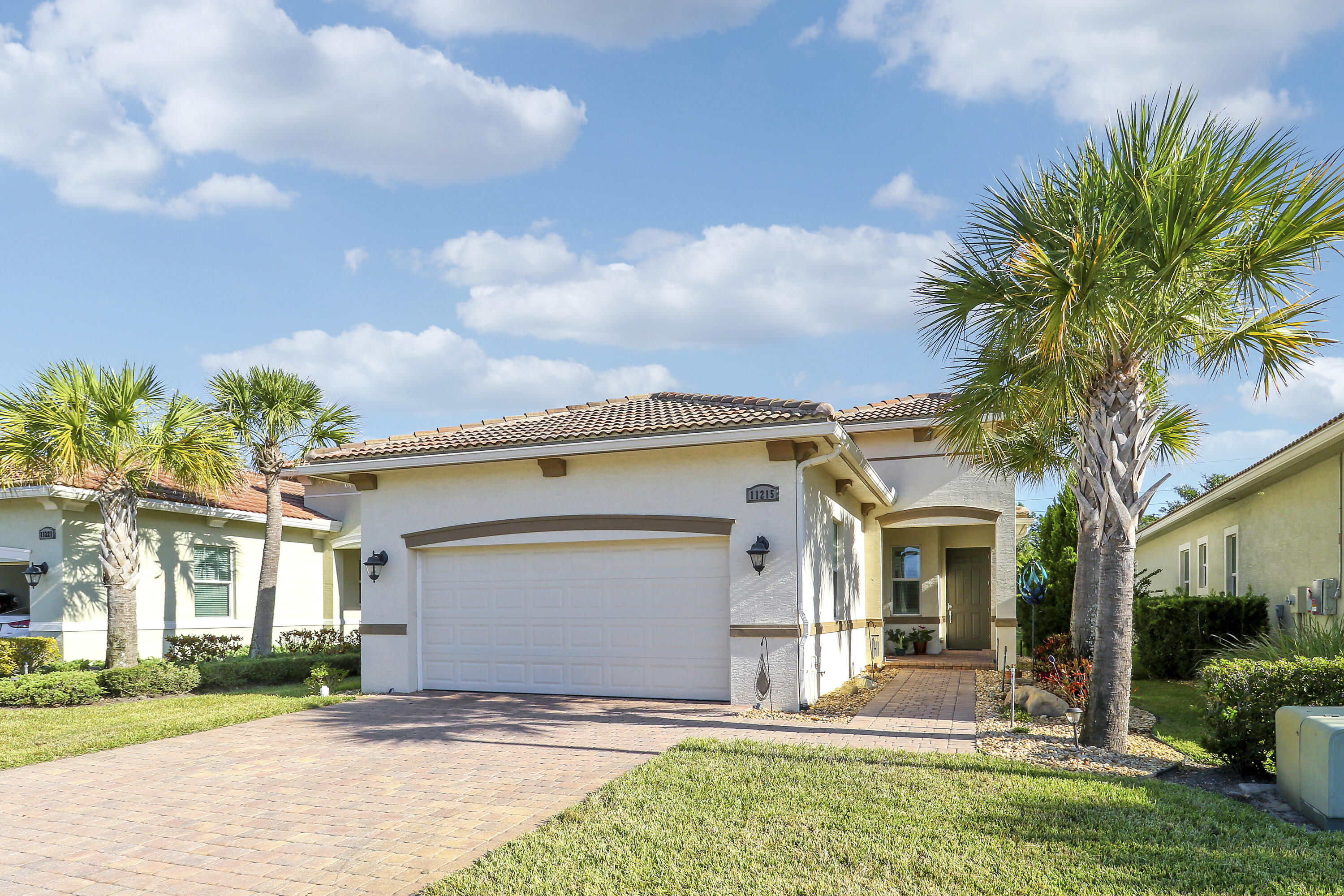 a view of a house with a yard and palm trees