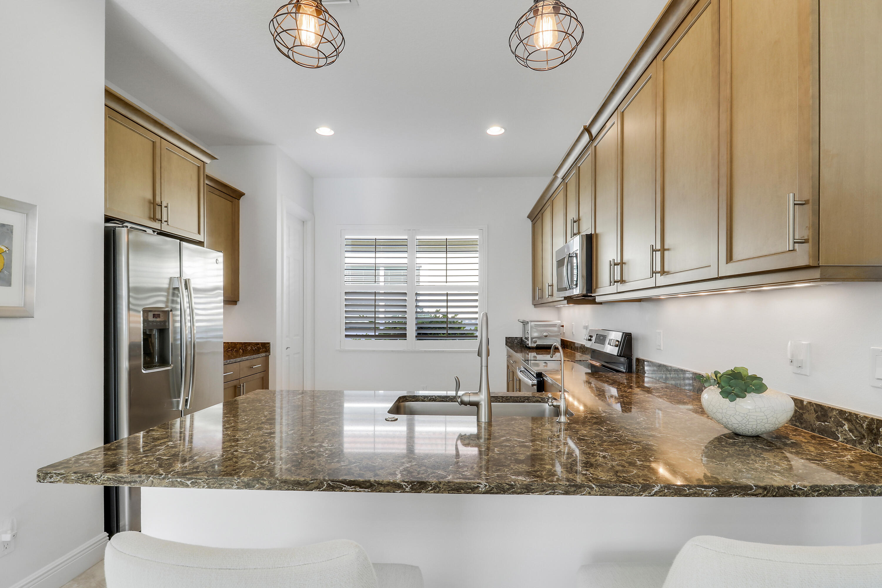 11215 Southwest Visconti Way Port St. Lucie, FL 34986 - Photo 12 of 61 a kitchen with kitchen island granite countertop a sink a stove cabinets and stainless steel appliances