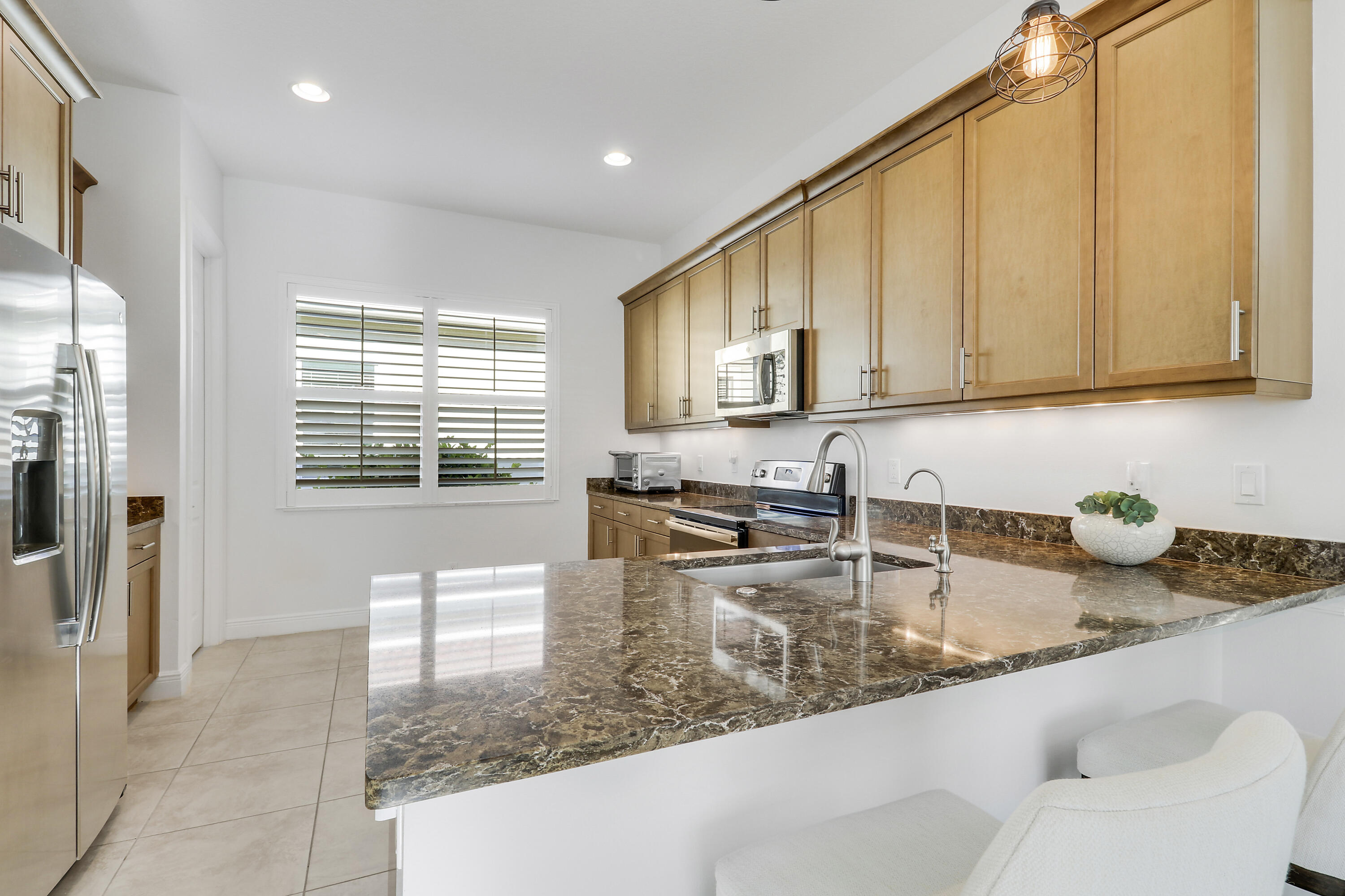 11215 Southwest Visconti Way Port St. Lucie, FL 34986 - Photo 13 of 61 a kitchen with sink cabinets and living room