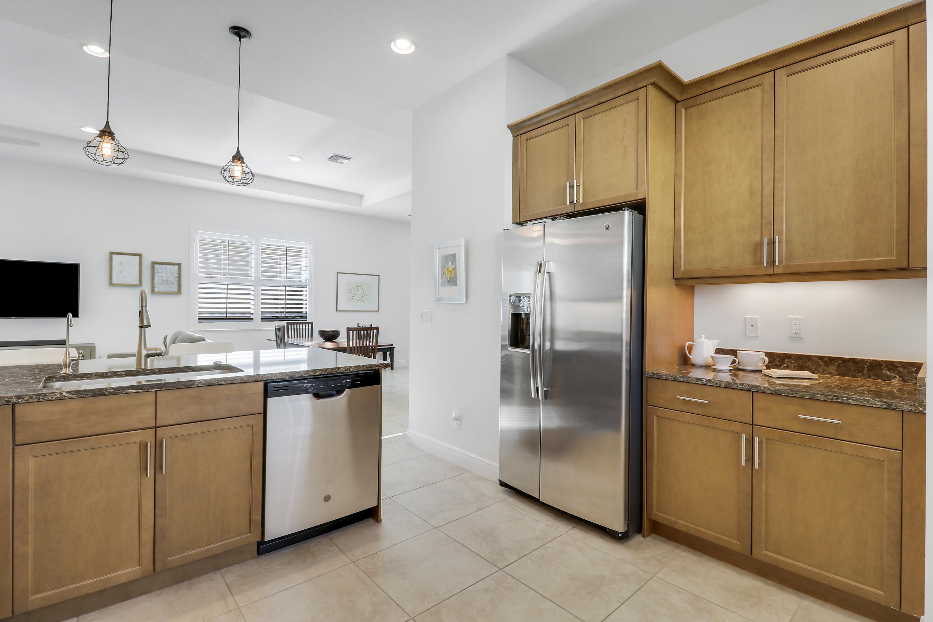 11215 Southwest Visconti Way Port St. Lucie, FL 34986 - Photo 16 of 61 a kitchen with stainless steel appliances granite countertop a refrigerator a sink and white cabinets