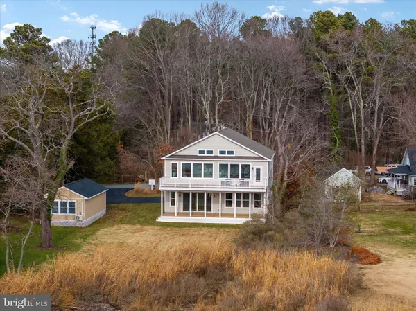a view of a house with a big yard and large trees