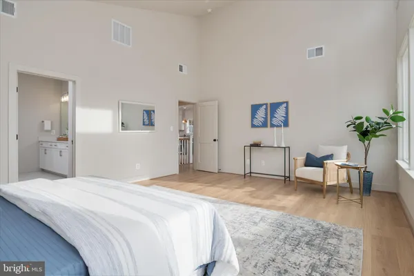 a spacious bedroom that has a bed and a table in it