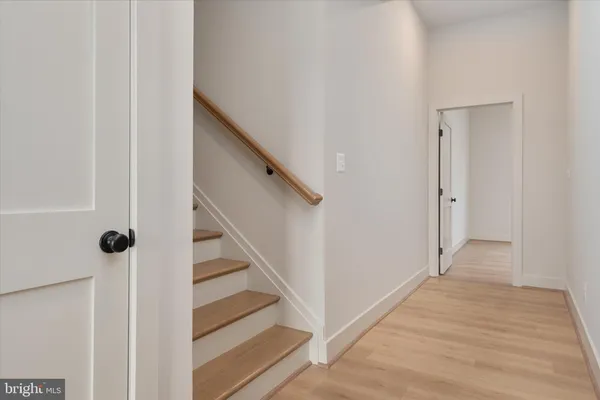 a view of a hallway with wooden floor and staircase