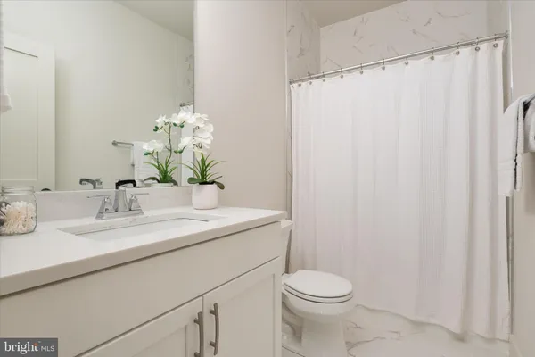 a bathroom with a granite countertop sink a toilet and a mirror