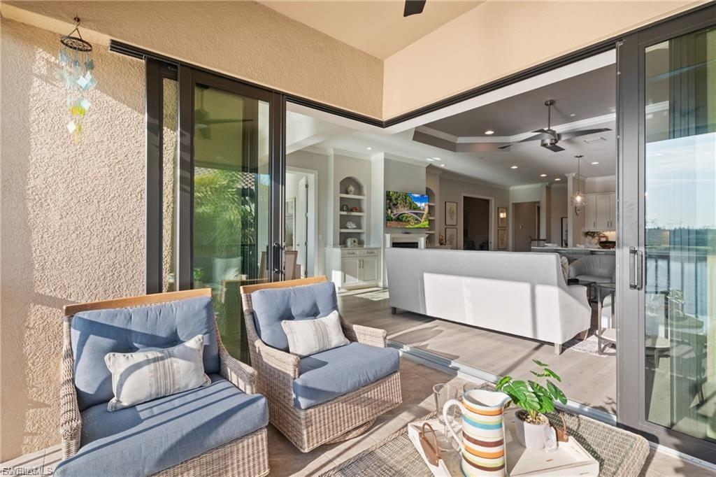 9642 Montelanico Loop, Unit 201 Naples, FL 34119 - Photo 12 of 27 a living room with furniture and a large window