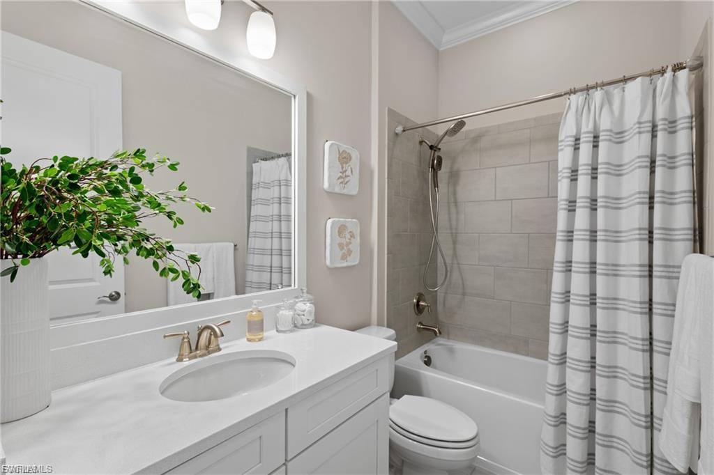 9642 Montelanico Loop, Unit 201 Naples, FL 34119 - Photo 15 of 27 a bathroom with a sink a toilet a tub and shower