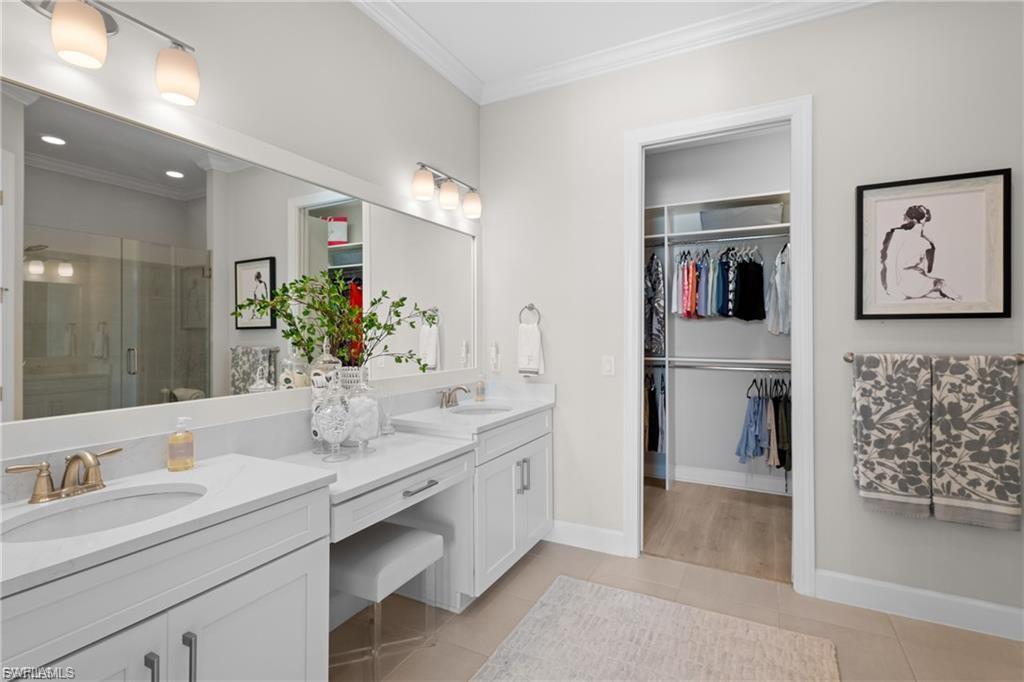 9642 Montelanico Loop, Unit 201 Naples, FL 34119 - Photo 18 of 27 a bathroom with a double vanity sink mirror and bathtub