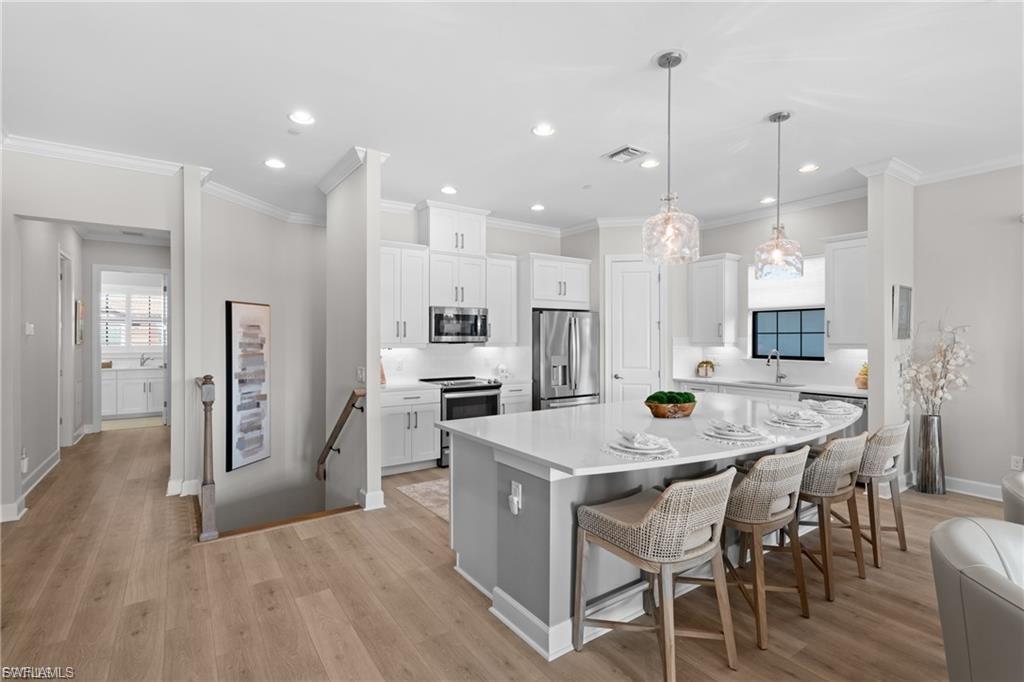 9642 Montelanico Loop, Unit 201 Naples, FL 34119 - Photo 26 of 27 a large kitchen with a table and chairs