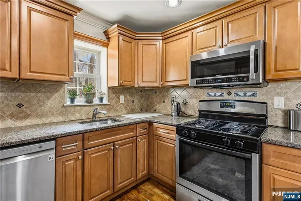 a kitchen with stainless steel appliances a stove sink and microwave