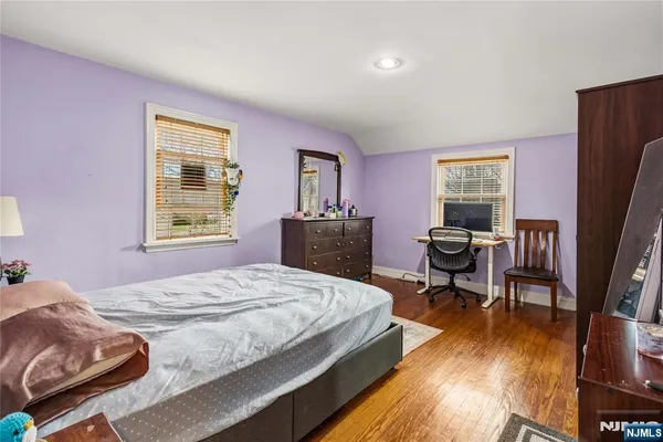 a bedroom with a bed and a dresser next to a window