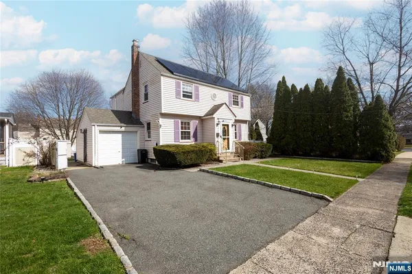 a front view of a house with a yard and trees