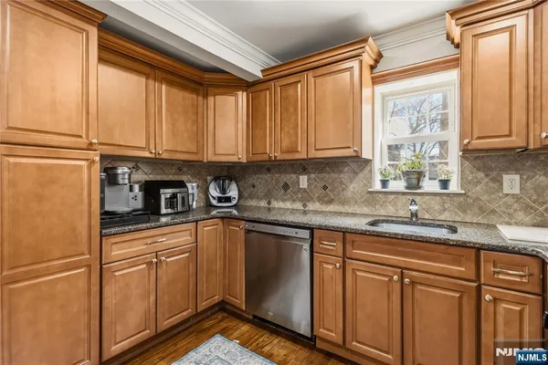 a kitchen with stainless steel appliances granite countertop a sink a refrigerator and cabinets