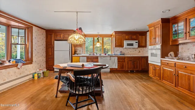 a dining hall with stainless steel appliances granite countertop a kitchen island a stove a table and chairs
