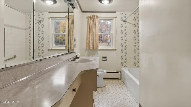 a bathroom with a tub sink and mirror