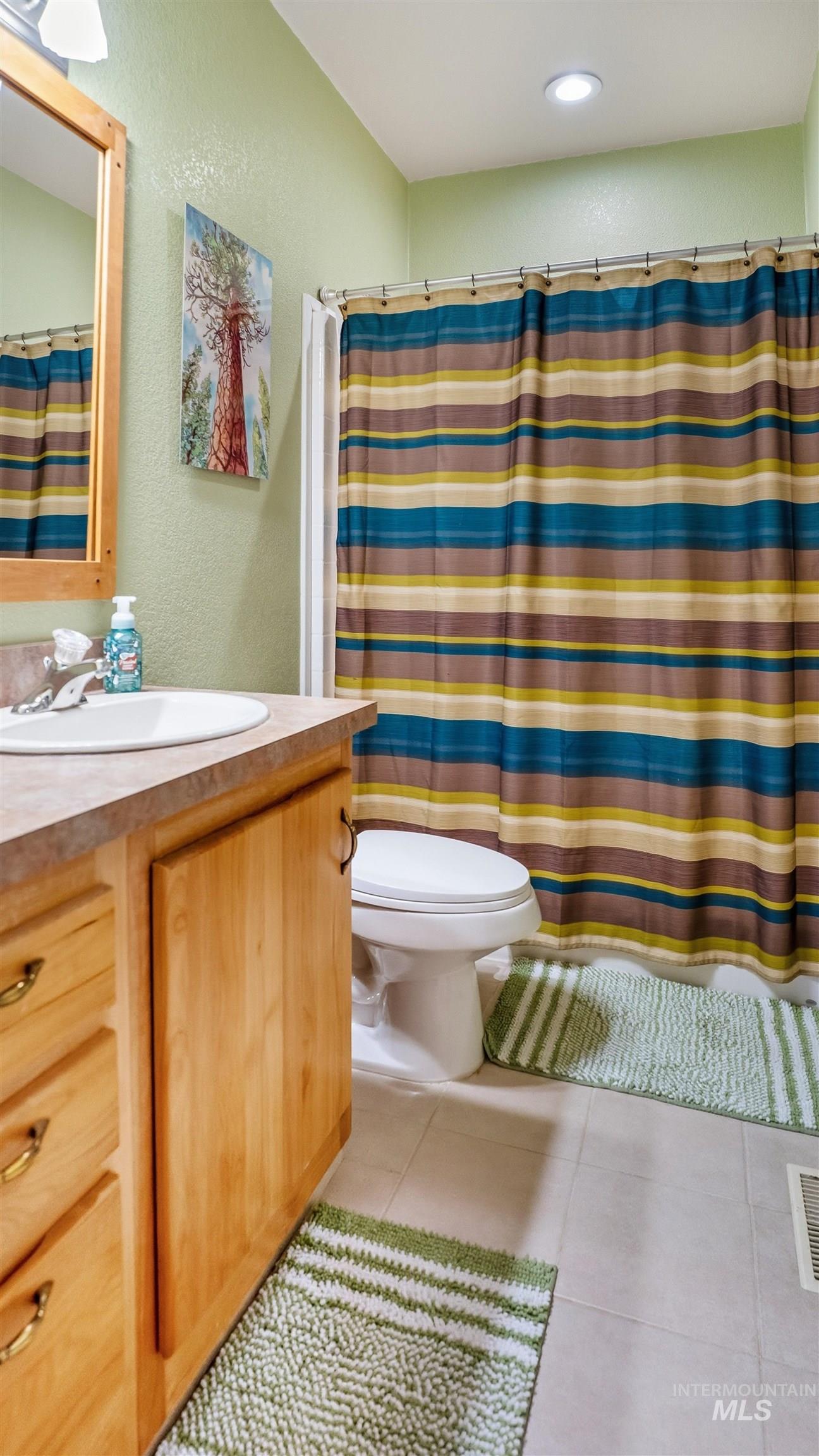 19397 Cloverland Road Asotin, WA 99402 - Photo 19 of 37 Bathroom with vanity, a textured wall, a shower with curtain, light tile patterned floors, and recessed lighting