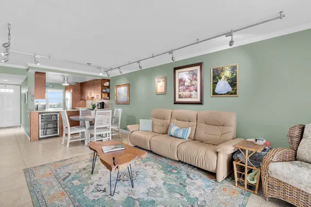a living room with furniture a wooden floor and kitchen view