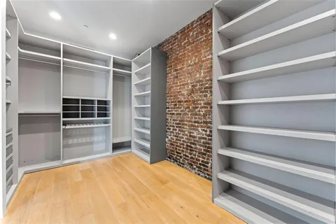 a view of walk in closet with empty racks