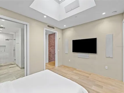 a bedroom with a bed and a flat screen tv