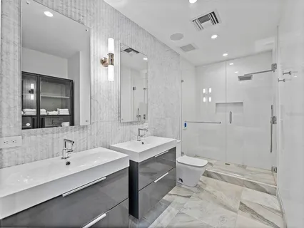 a bathroom with a double vanity sink mirror and toilet