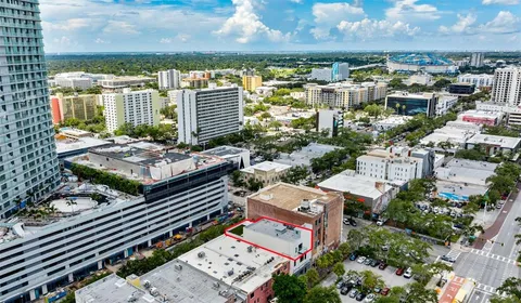 an aerial view of a city with lots of residential buildings ocean and mountain view in back