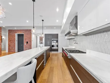 a large kitchen with kitchen island a large counter space a sink appliances and cabinets