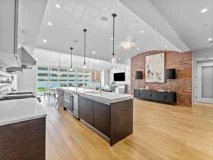 a kitchen with stainless steel appliances kitchen island a large counter top a sink and a stove