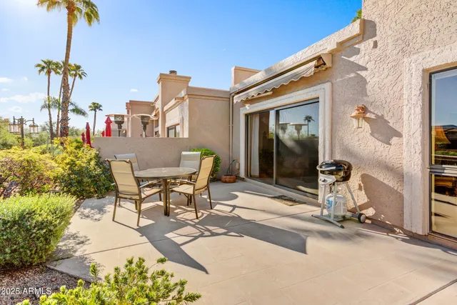 a view of a patio with table and chairs and potted plants