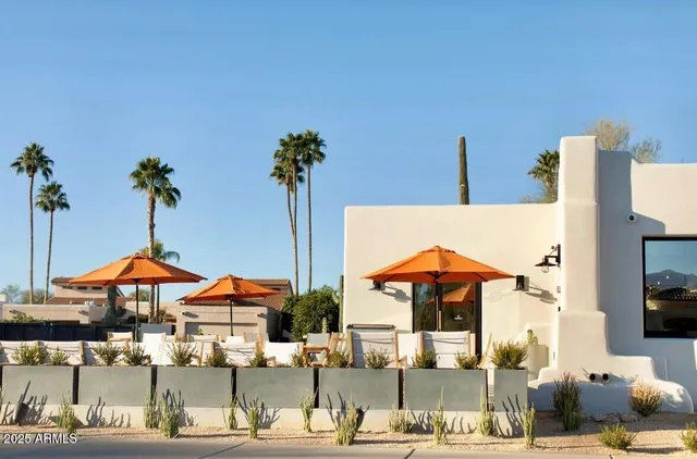 a view of a patio with chairs and table under an umbrella