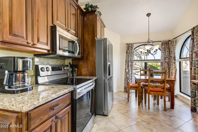 a kitchen with stainless steel appliances granite countertop a stove refrigerator and cabinets