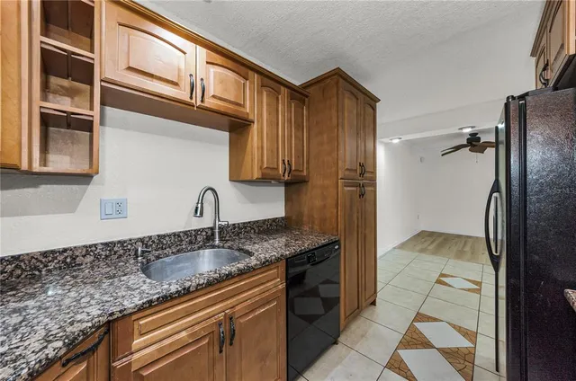 a kitchen with stainless steel appliances granite countertop a refrigerator and cabinets