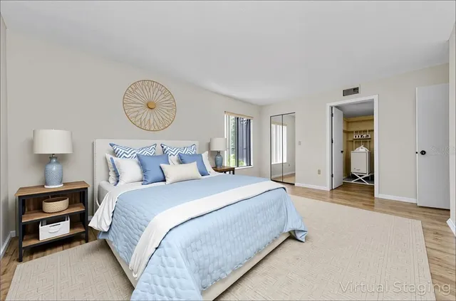 a spacious bedroom with a bed and lamp