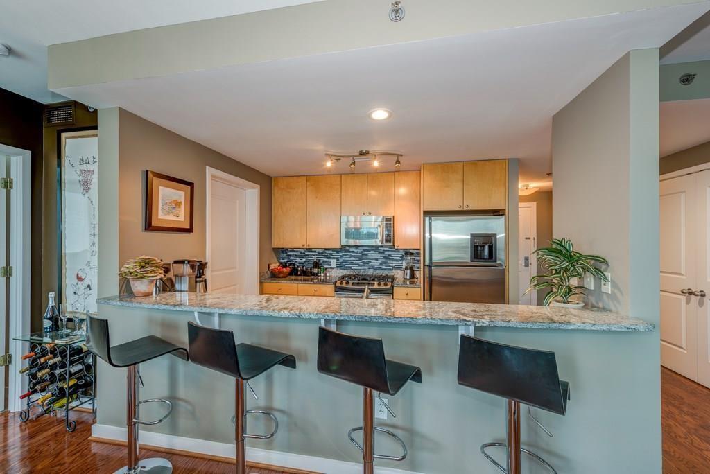 3338 Peachtree Road Northeast, Unit 809 Atlanta, GA 30326 - Photo 8 of 23 a room with stainless steel appliances kitchen island granite countertop furniture and a large window