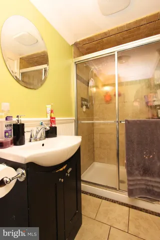 a bathroom with a sink mirror and shower