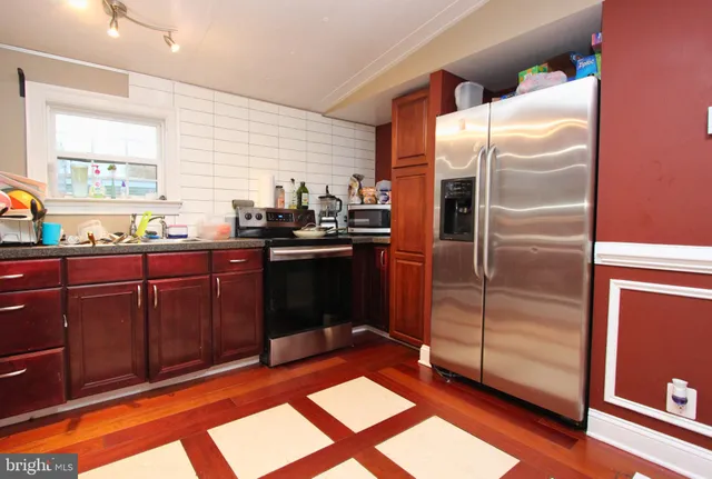 a kitchen with granite countertop stainless steel appliances and wooden cabinets