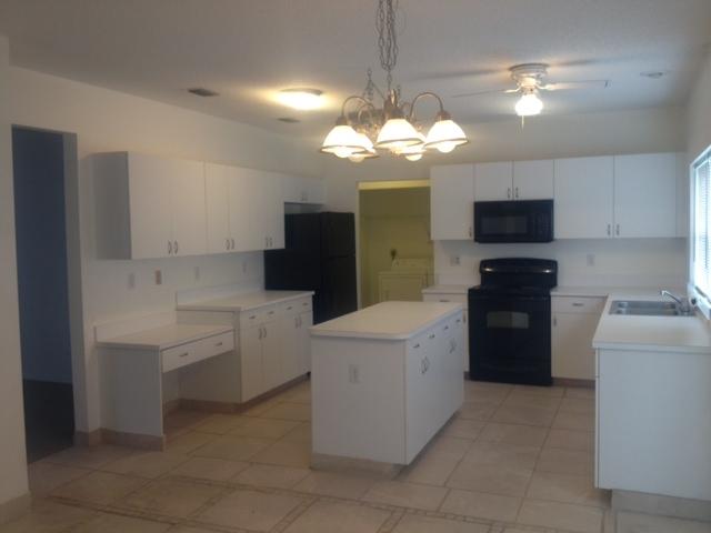 3870 Sabal Lakes Road Delray Beach, FL 33445 - Photo 9 of 17 a kitchen that has a lot of cabinets in it and a chandelier
