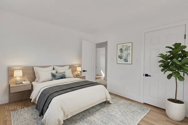a bedroom with bed and a potted plant