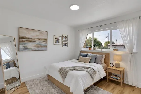 a bedroom with a bed and wooden floor