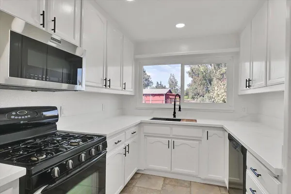 a kitchen with white cabinets stainless steel appliances and sink