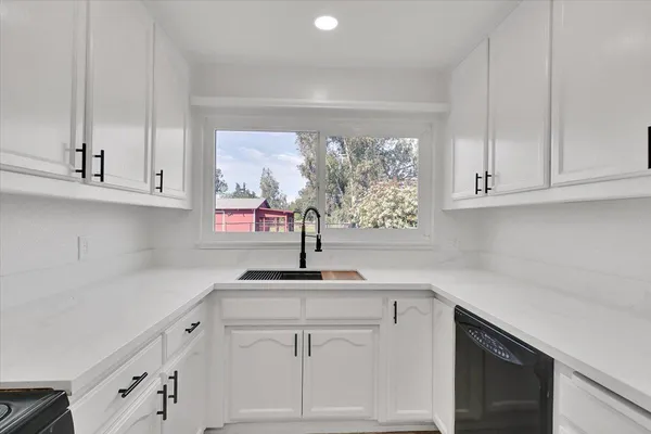 a kitchen with white cabinets and a sink