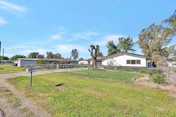 a view of a house with a yard and basketball court