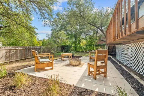 a view of a patio with a dining table and chairs with wooden floor