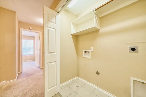 a view of a hallway with wooden floor and a bathroom