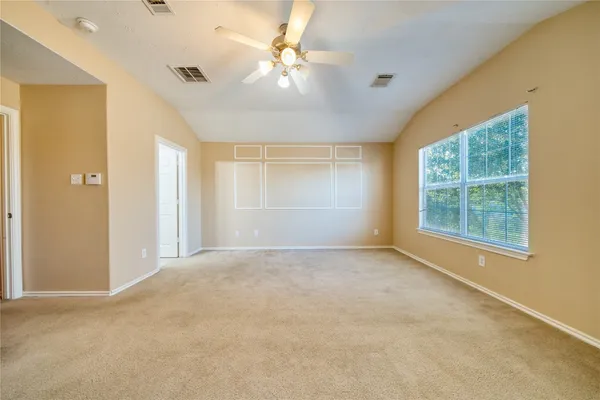 en empty room with windows and chandelier fan