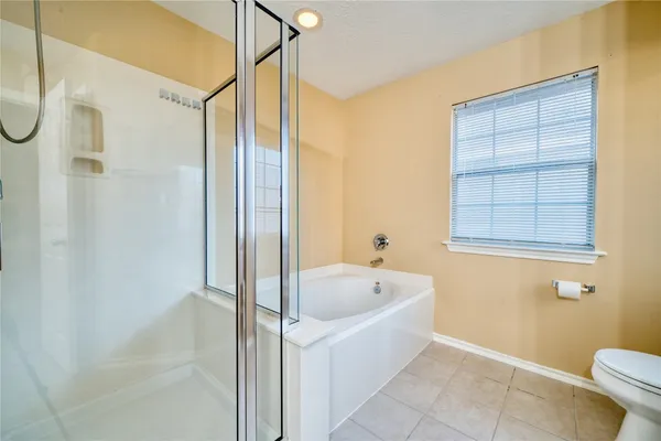 a bathroom with a tub a window and a shower