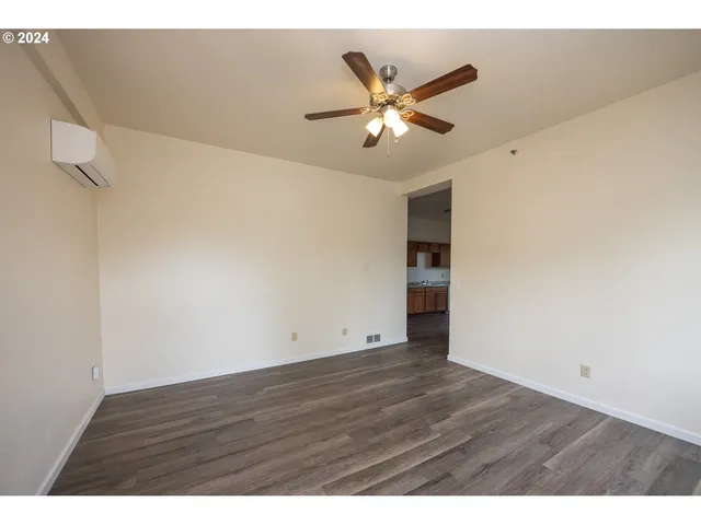 a view of an empty room with wooden floor