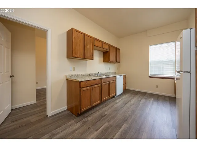 a view of a kitchen with wooden floor and a sink