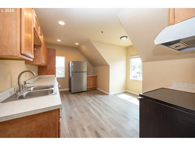 a kitchen with kitchen island a sink stainless steel appliances and cabinets