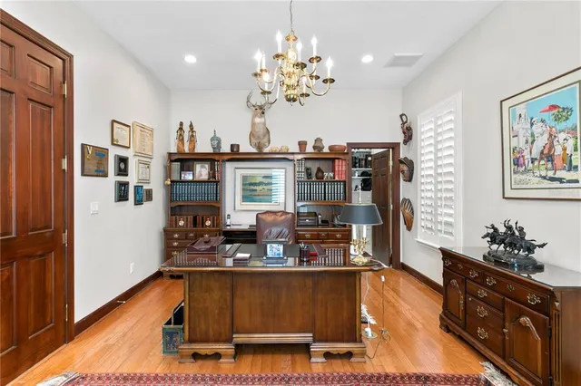 a large kitchen with kitchen island granite countertop a dining table chairs and white cabinets