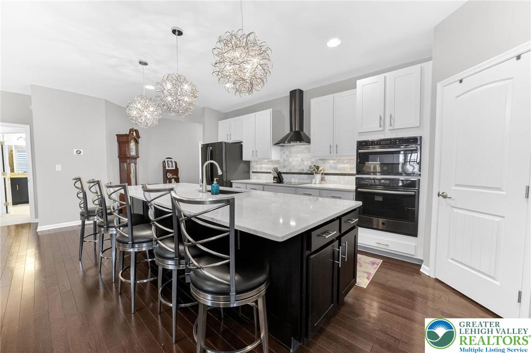 3465 Treeview Drive Emmaus, PA 18049 - Photo 5 of 38 a kitchen with stainless steel appliances a table chairs and wooden floor