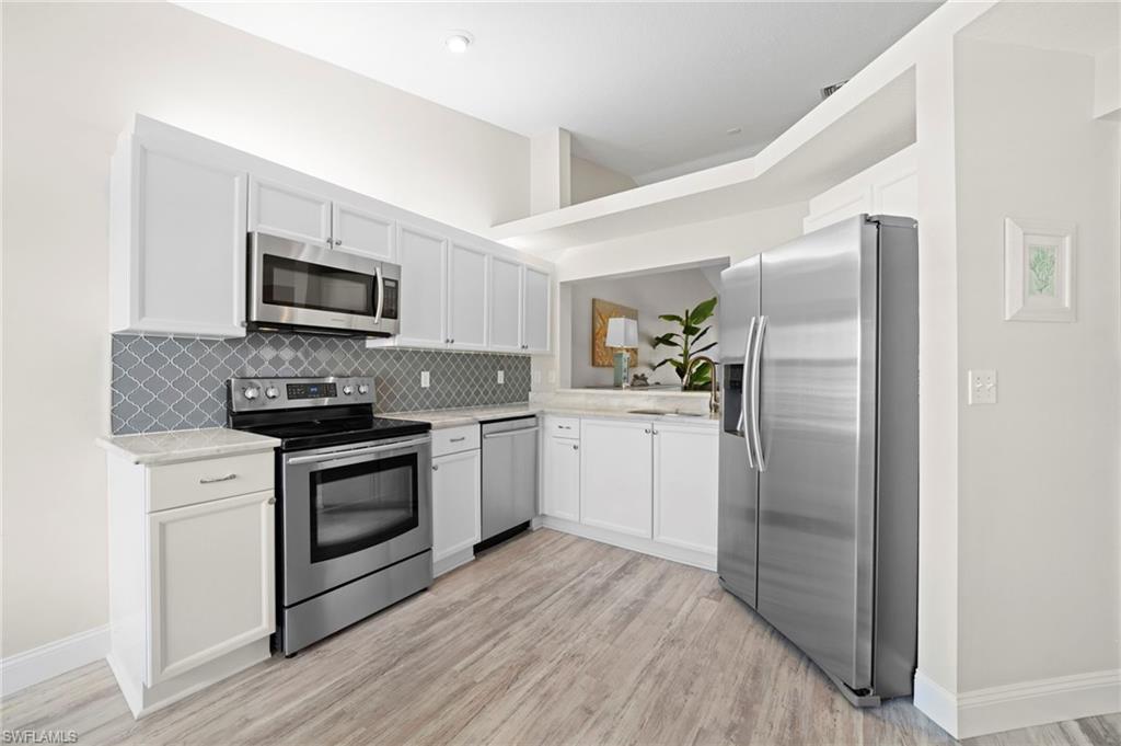 13120 Castle Harbour Drive, Unit N4 Naples, FL 34110 - Photo 12 of 36 a kitchen with a refrigerator stove and sink
